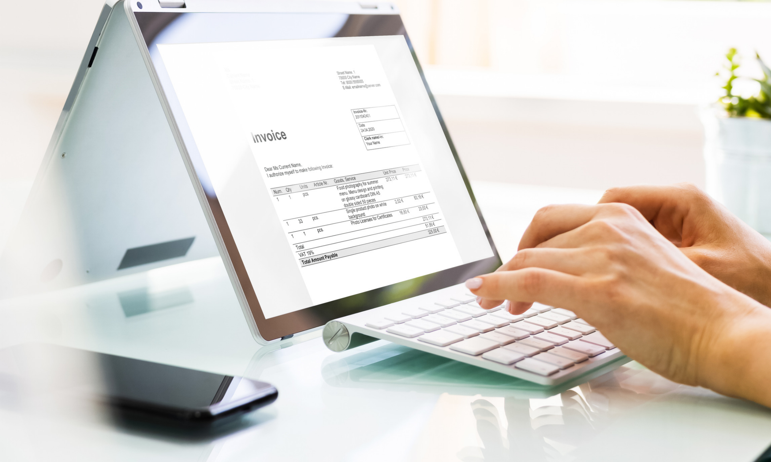 Hand typing on a screen showing invoice
