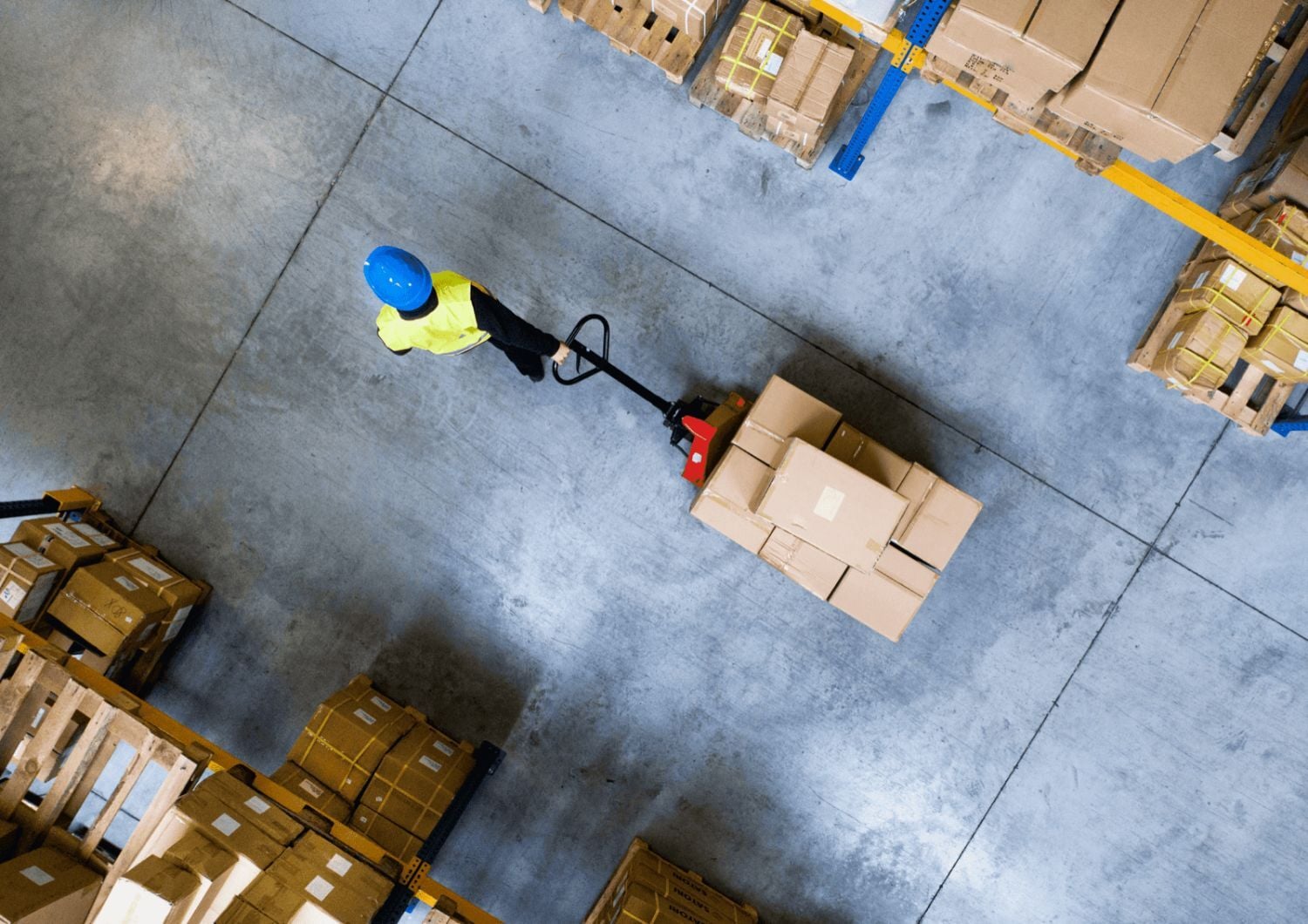 A man pulling a pallet with boxes on it